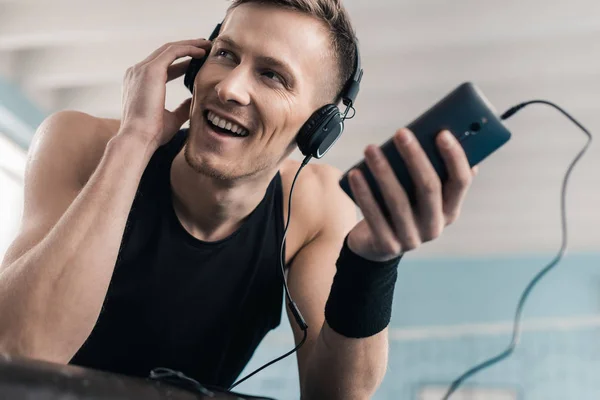Спортсмен в навушниках зі смартфоном — стокове фото