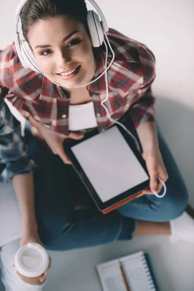 Vrouw in koptelefoon met tablet — Stockfoto