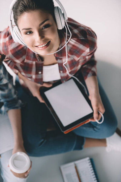 женщина в наушниках с планшетом
