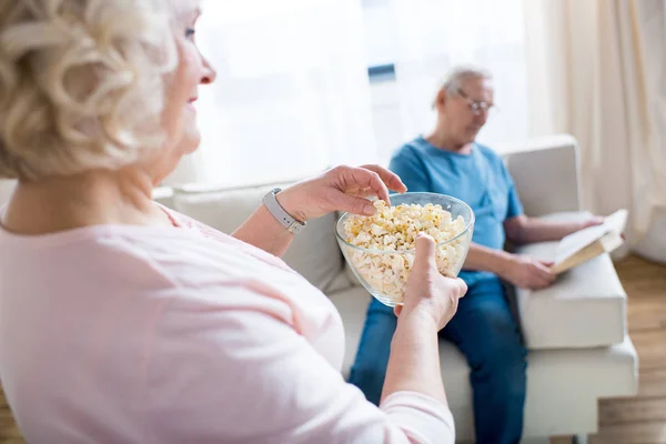 Senior woman eating popcorn — Stock Photo, Image