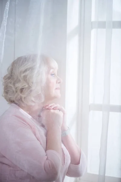 Mujer mayor en la ventana —  Fotos de Stock