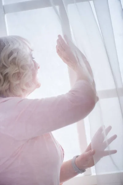 Senior woman at window — Stock Photo, Image