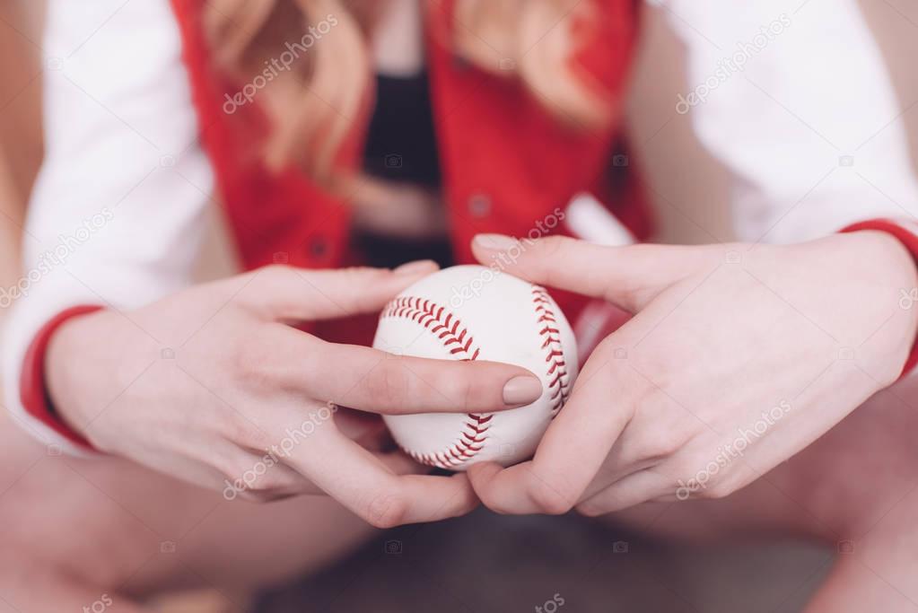 Woman holding baseball ball 