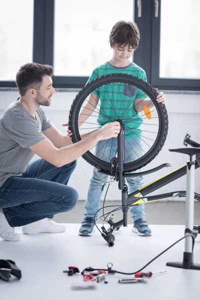 Father and son repairing bicycle — Stock Photo, Image