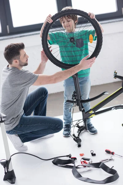 Pai e filho reparando bicicleta — Fotografia de Stock