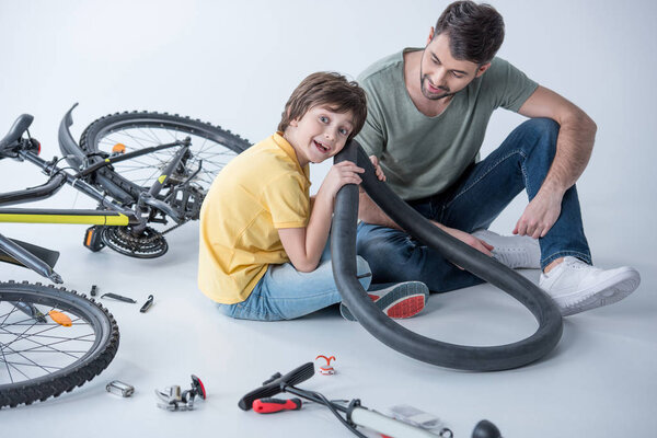 Отец и сын ремонтируют велосипед
 