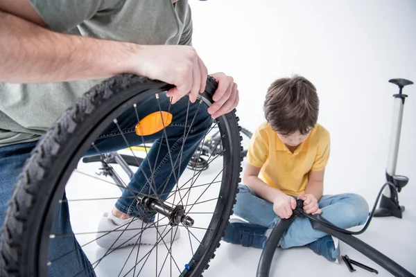 Son and father repairing bicycle — Stock Photo, Image