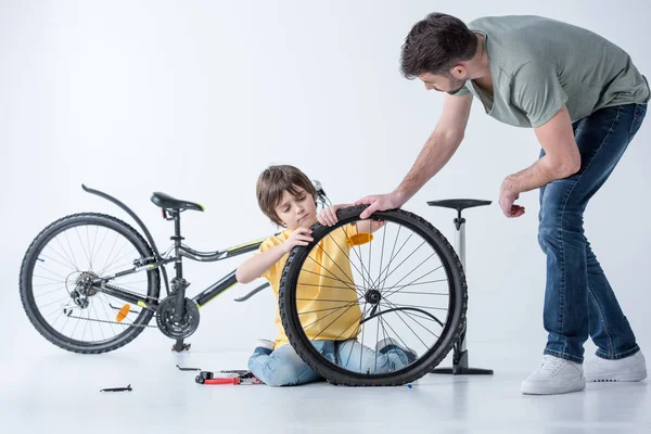 Filho e pai reparando bicicleta — Fotografia de Stock