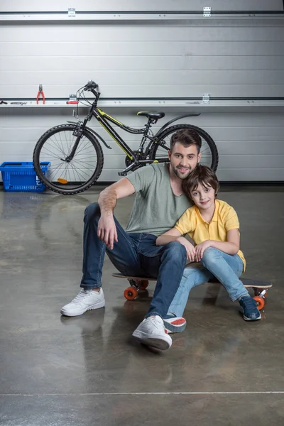 Отец и сын на скейтборде — стоковое фото