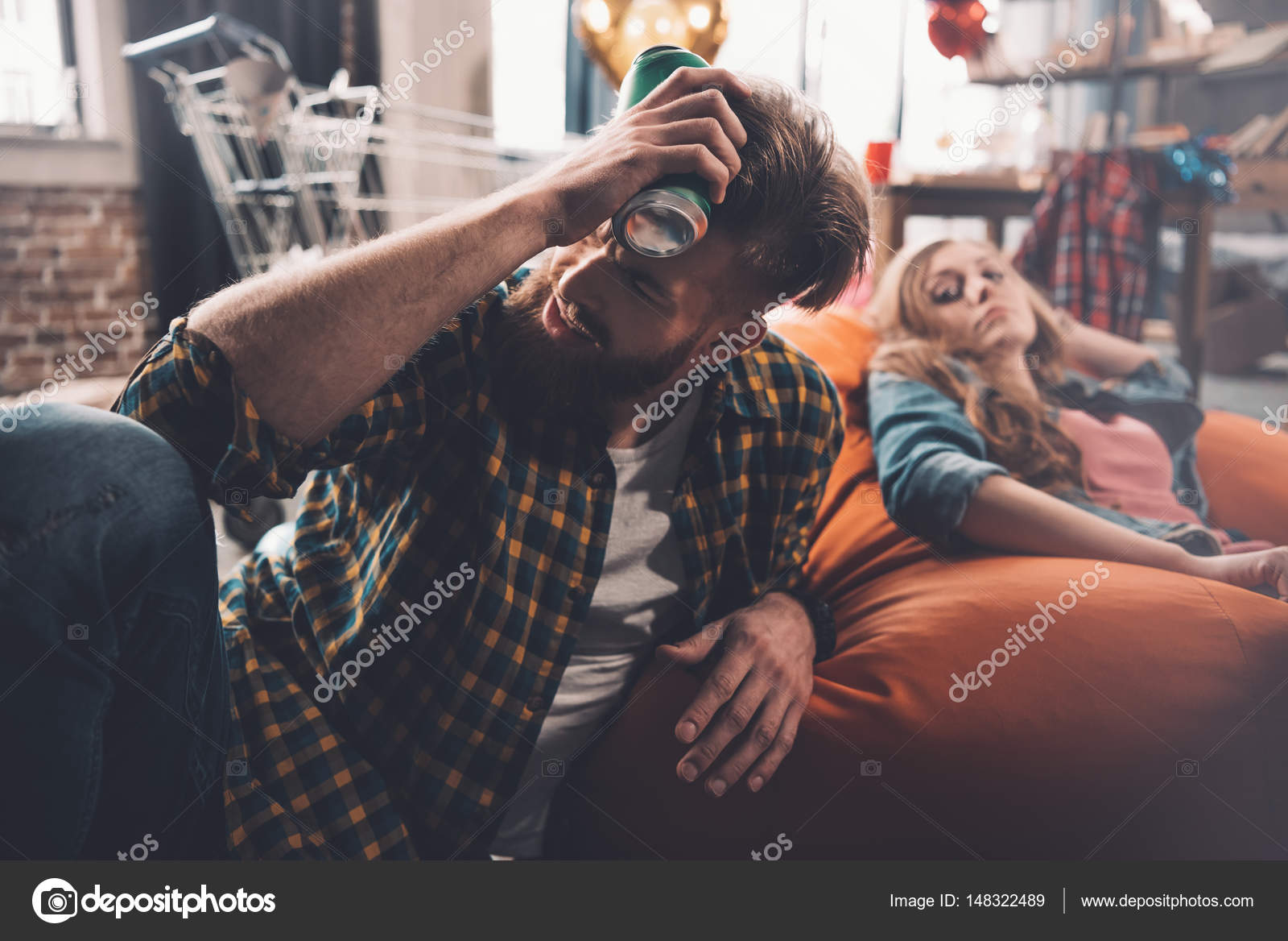 Man with headache holding beer Stock Photo by ©ArturVerkhovetskiy 148322489