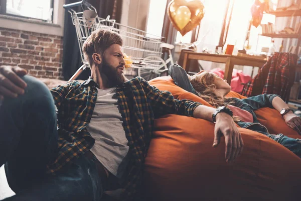 Tired couple resting on beanbag chair — Stock Photo, Image