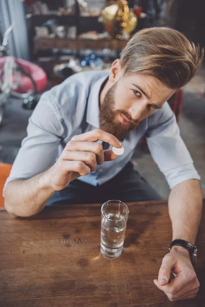 Uomo con postumi di sbornia con medicinali — Foto Stock