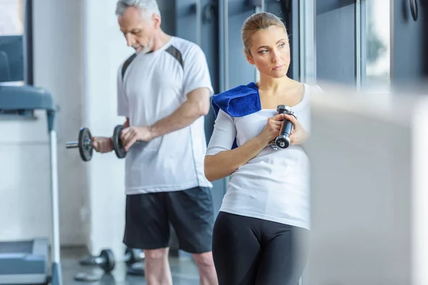 Sportswoman and sportsman training with dumbbells — Stock Photo, Image