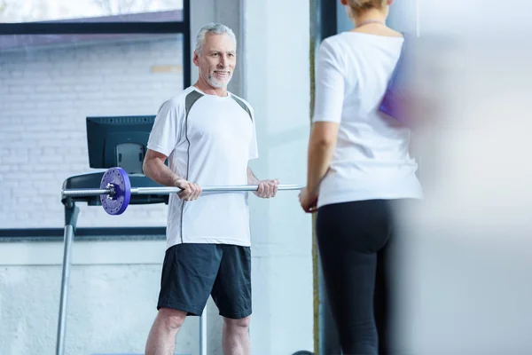 Hombre con barra y deportista en gimnasio —  Fotos de Stock