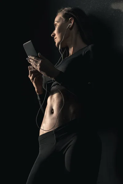 Спортивна жінка використовує смартфон — стокове фото