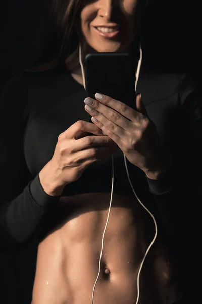 Sporty woman using smartphone — Stock Photo, Image