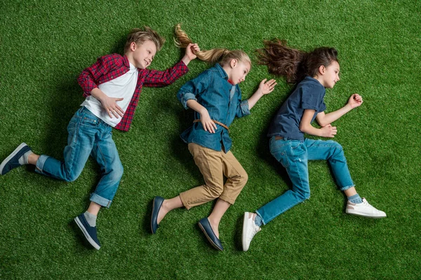 Kinderen liggen op gras — Stockfoto