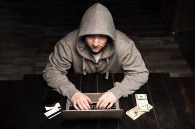 Hacker using laptop  clipart