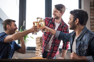 Diverse group of young people playing jenga game and drinking beer stock vector