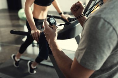 woman workout on treadmill and trainer with timer, side view  clipart