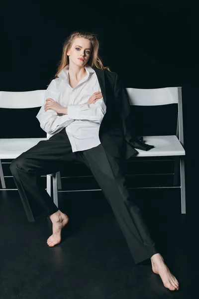 Vrouw in mannelijke shirt zitten op stoelen — Stockfoto