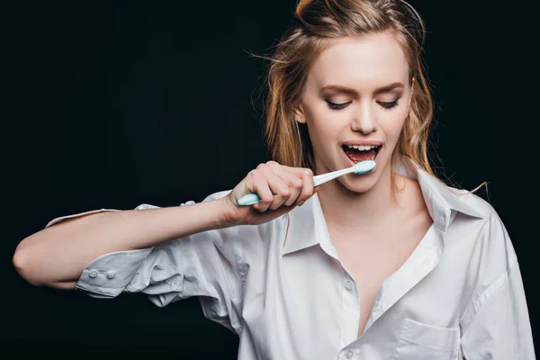 Woman in male shirt brushing teeth — Stock Photo, Image