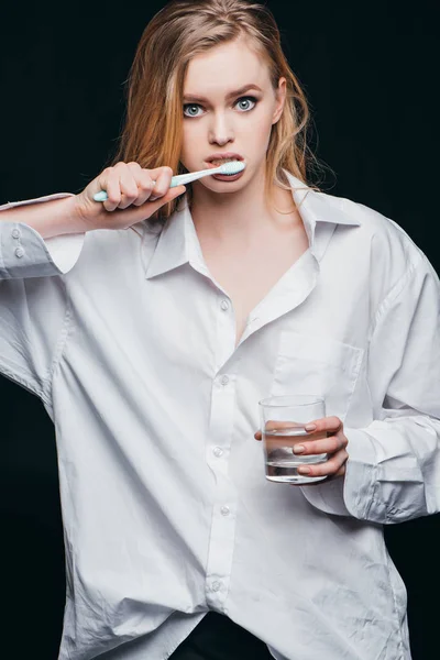 Woman in male shirt brushing teeth — Stock Photo, Image