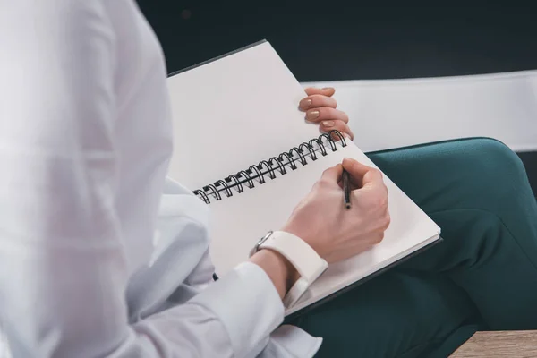 Mujer escribiendo notas en bloc de notas — Foto de Stock