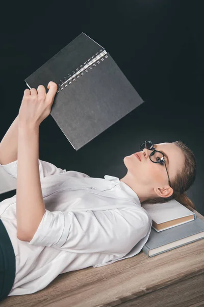 Woman lying on table and reading notes — Stock Photo, Image