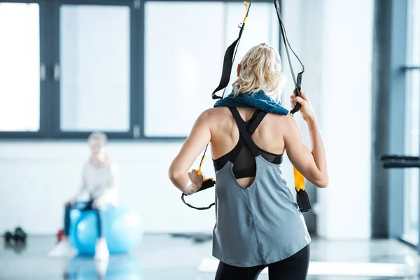 Blonde fitness woman training with trx fitness straps — Stock Photo, Image