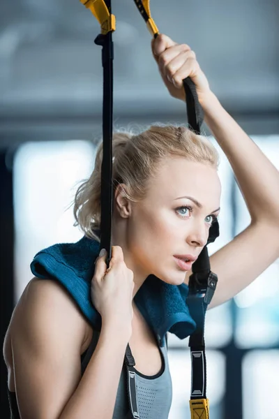 Mooie fitness vrouw rusten tijdens het trainen met trx fitness riemen — Stockfoto