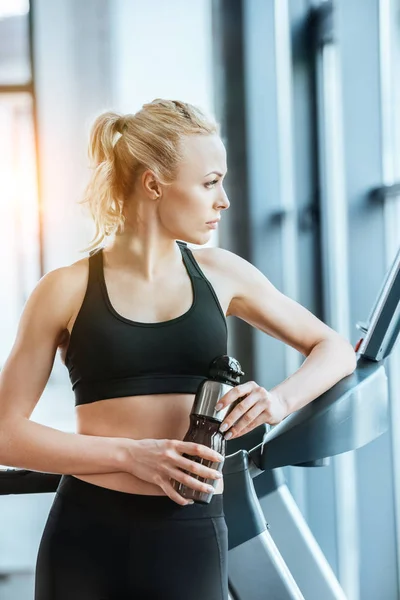 Mujer atractiva joven descansando después del entrenamiento en la cinta de correr — Foto de Stock