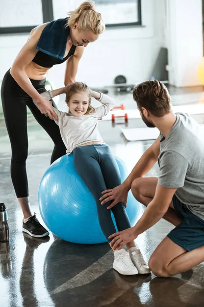 Söt tjej tränar på swiss ball med föräldrar — Stockfoto