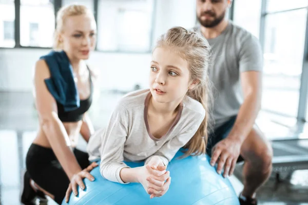 Cute gir exercising on swiss ball with parents — Stock Photo, Image