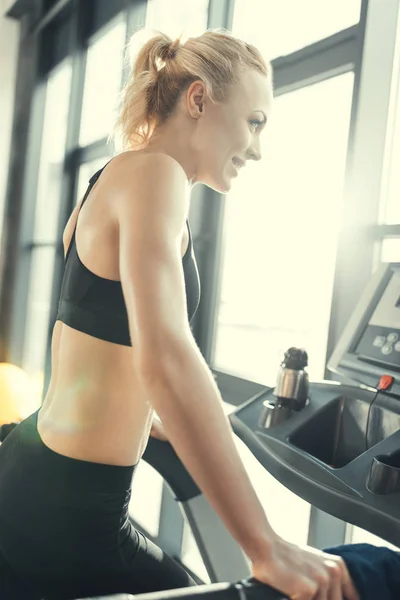 Rubia entrenamiento de mujer en la cinta de correr, vista lateral —  Fotos de Stock