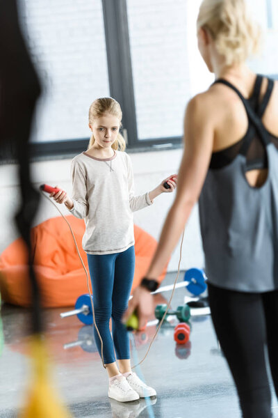 Young fitness people exercising with skipping ropes at sports center