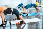 Lidé dělají gymnastika, provádění most představují ve fitness studiu 