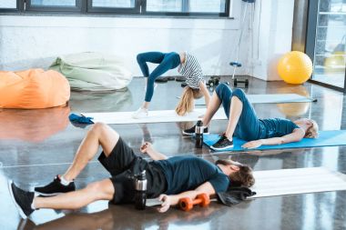 İnsanlar jimnastik yapıyor, kız performans gösteren köprü poz fitness stüdyosu 