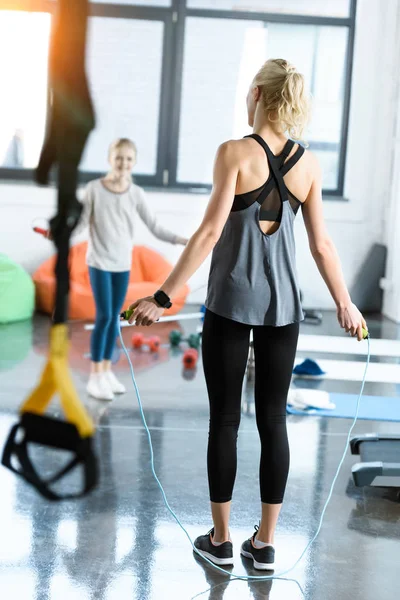 Young fitness people exercising with skipping ropes at sports center — Stock Photo, Image