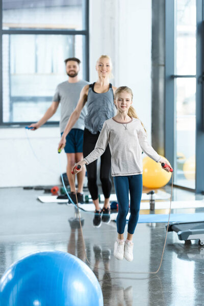 Young fitness people exercising with skipping ropes at sports center