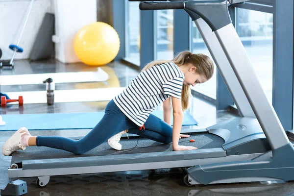Girl stretching on treadmill before training — Stock Photo, Image