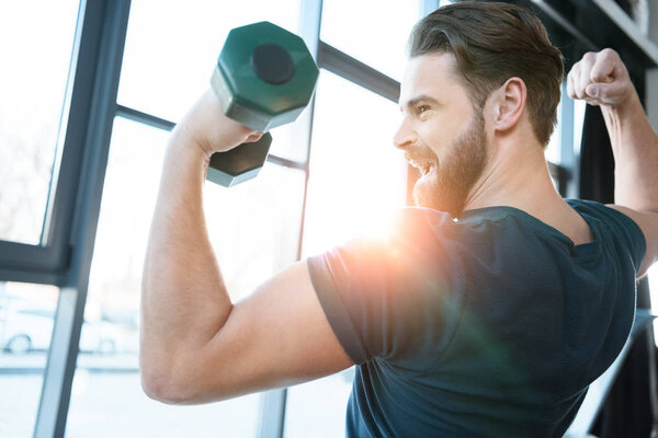 Handsome young guy workout with dumbbell