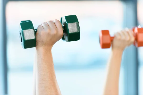 Hands holding dumbbells at fitness studio — Stock Photo, Image