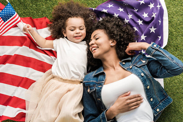 женщина с дочерью на американском флаге
