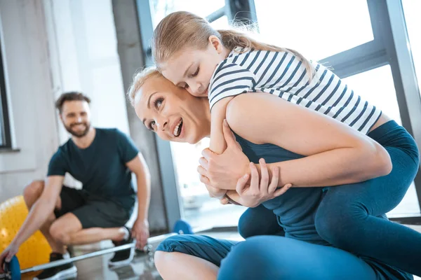 Menina bonito abraçar a mãe no clube de fitness — Fotografia de Stock