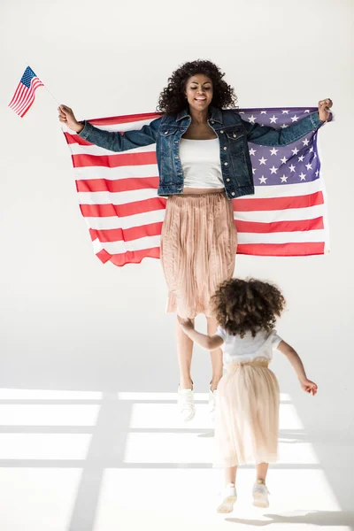 Vrouw en dochter springen met Amerikaanse vlag — Stockfoto