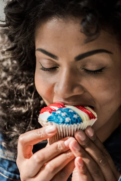 Amerykańska dziewczyna bite cupcake — Zdjęcie stockowe