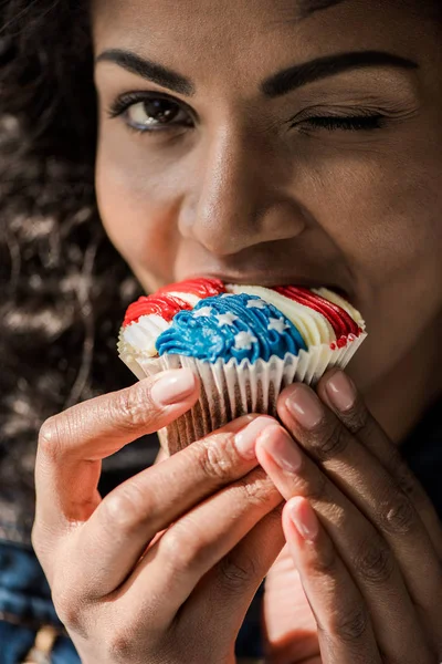 Chica americana morder cupcake — Foto de Stock