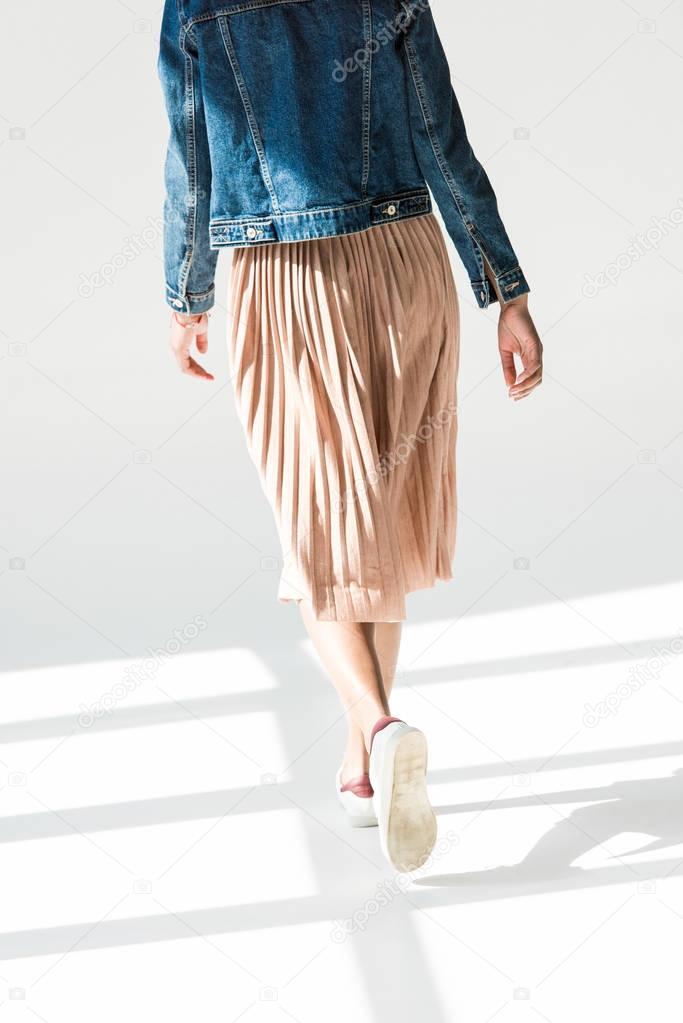 woman in beige skirt and denim jacket