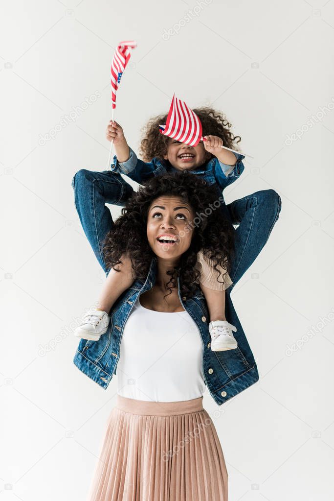 daughter sitting on shoulders of mother